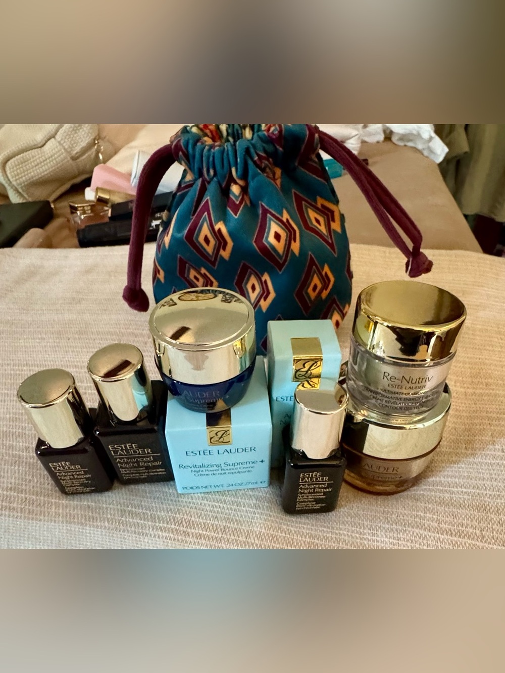 Estee Lauder teal and gold skincare set with patterned drawstring pouch